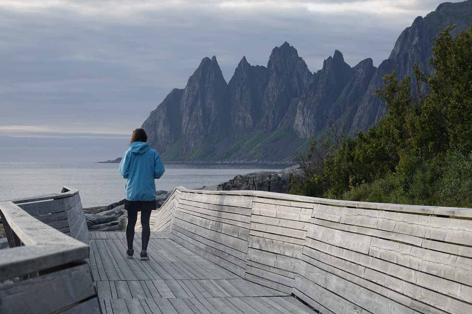 woman walking towards sea on one of norwegian scenic routes